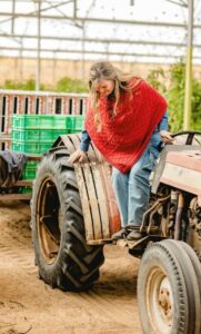 Kari Warberg Block stepping down from a tractor.